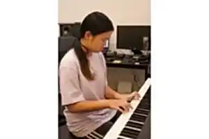 Teenage girl performing on piano under guidance of her music teacher at Besharp Music School, Adelaide.