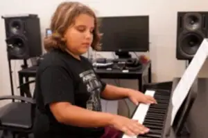 Young boy playing piano at Besharp Music School, Adelaide, demonstrating his musical talent and passion.
